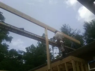 Carpenter setting a ridge beam over a new addition frame — Ice Dam Removal by Roofing Brothers in Gunter
