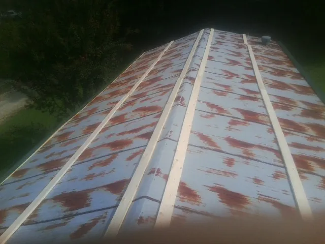 Rusted metal roof panels with new wood purlins before replacement — Storm Damage Roof Repair in Gunter by Roofing Brothers