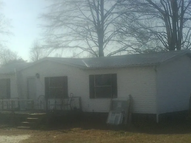 New metal roof on a white painted brick home on a foggy morning in Gunter