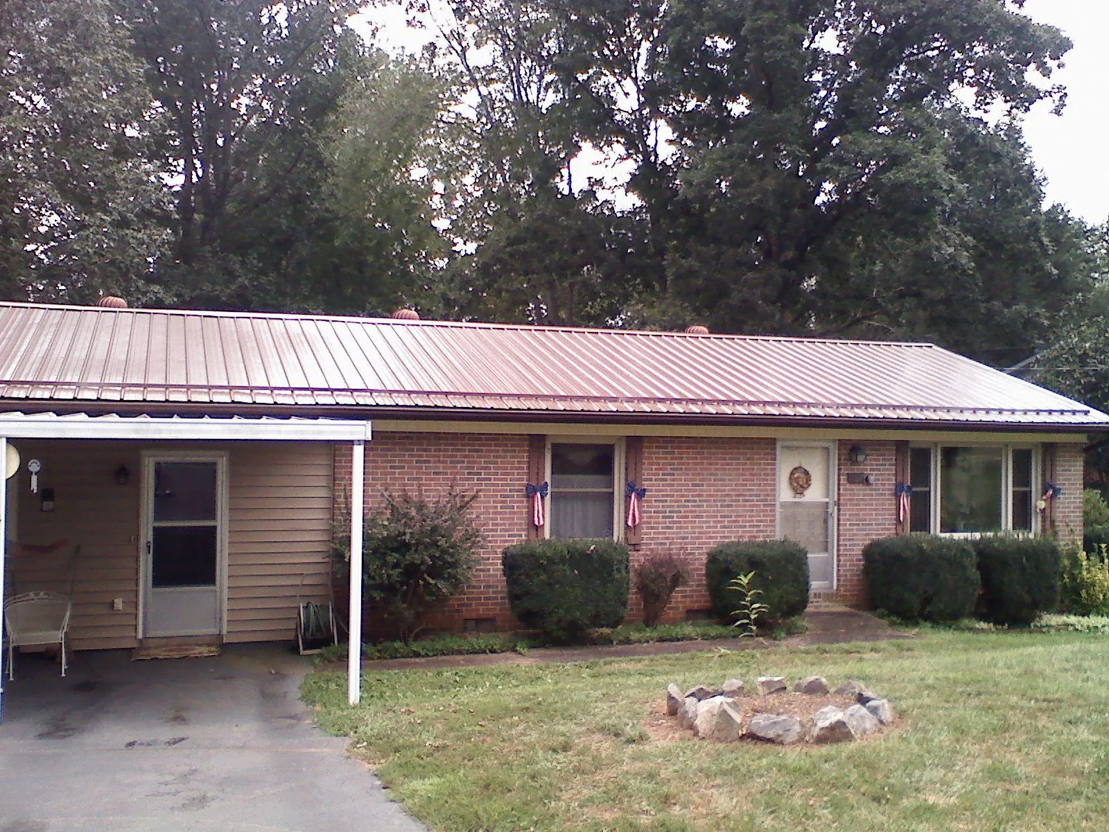 Bronze metal roof and carport on a brick ranch home — Roof Repair work by our crew in Gunter