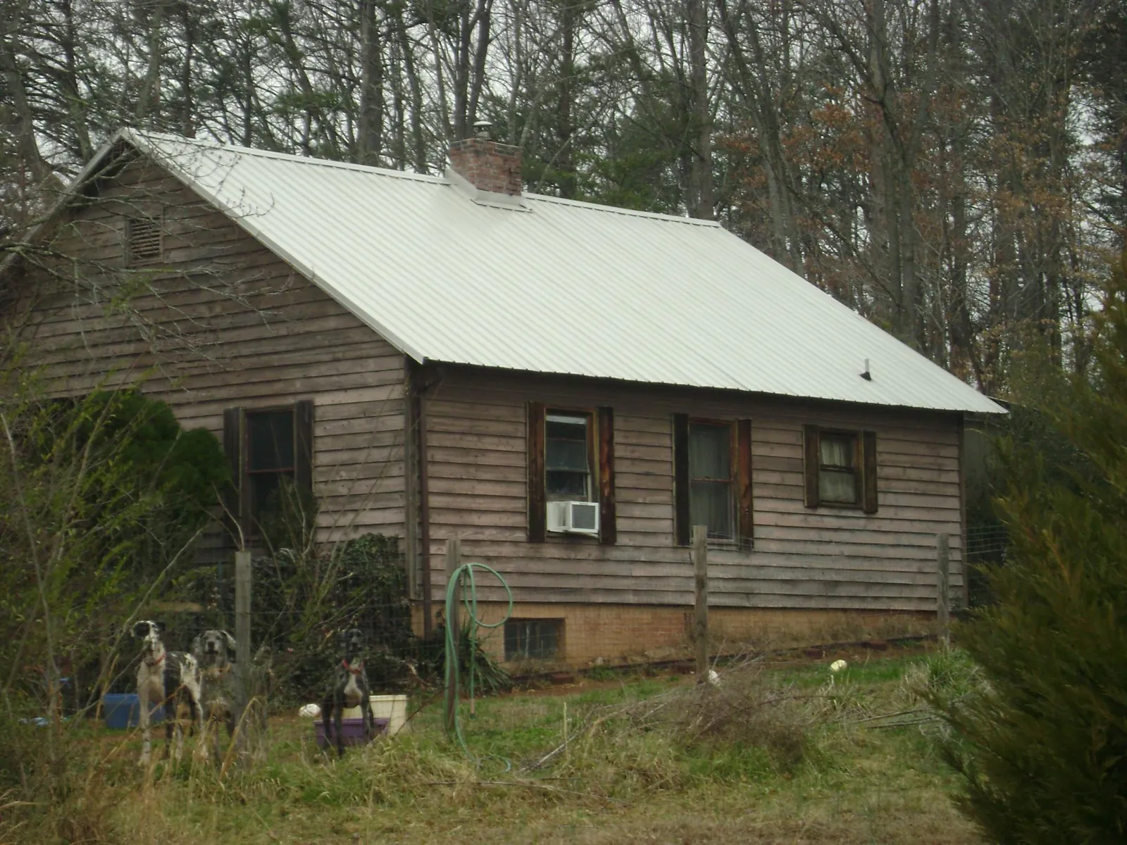 White metal roof on an old wood sided farmhouse, from a Metal Roof Installation job in Gunter